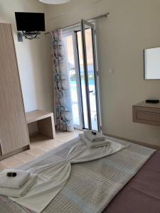 Habitación con ventana y 2 toallas en una cama en Angelica Studios and Apartments en Agia Marina Nea Kydonias