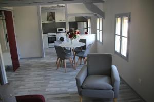 ein Esszimmer und eine Küche mit einem Tisch und Stühlen in der Unterkunft Les appartements du Saint Hubert in Arcis-sur-Aube