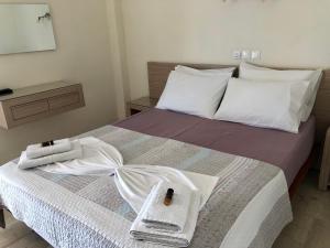 a hotel room with a bed with towels on it at Angelica Studios and Apartments in Agia Marina Nea Kydonias