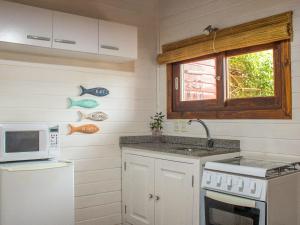 uma cozinha com um lavatório e um micro-ondas em Bon Amour Punta del Diablo em Punta Del Diablo