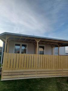 a house with a wooden fence in front of it at CHALETS MERCURE am Wallersee zum Vermieten in Helming