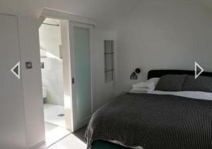a bedroom with a large bed and a bathroom at Stylish home in Streatham. in London