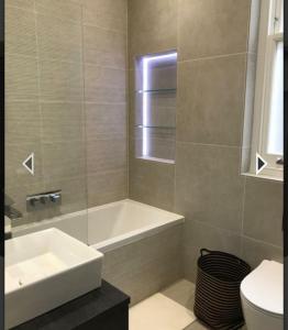 y baño con lavabo, bañera y aseo. en Stylish home in Streatham., en Londres