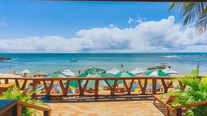 a beach with a bunch of umbrellas and the ocean at Pousada Flor de Lua in Morro de São Paulo