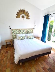 a bedroom with a large white bed with blue curtains at Villa Martinus in Saint-Paul-de-Vence