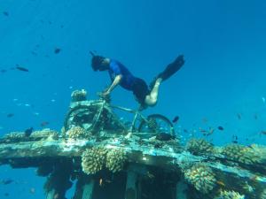 a man riding a bike over a coral reef at Ocean Vista Maldives,Maafushi in Maafushi
