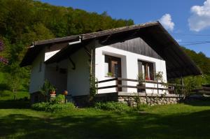 ein kleines weißes Haus mit einem Holzdach in der Unterkunft Вила Даяна in Ribarica