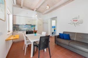 a kitchen and living room with a table and a couch at Casammare in Marina di Modica