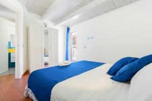 una camera da letto con un grande letto con cuscini blu di Casammare a Marina di Modica