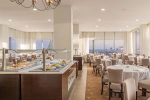 a restaurant with tables and chairs and a buffet at Sao Miguel Park Hotel in Ponta Delgada