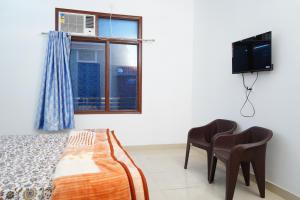 - une chambre avec un lit, une télévision et une fenêtre dans l'établissement Roop Niwas, à Amritsar