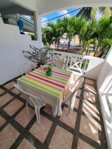 uma mesa listrada e cadeiras numa varanda com palmeiras em Appartement & Studio Lolla em Pereybere