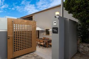 a gate leading to a patio with a table and a house at Amaré Chania Luxury Residence in Stérnai