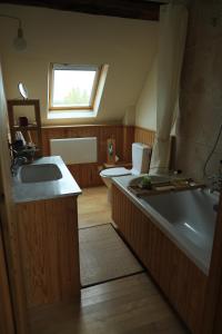 uma casa de banho com uma banheira e um lavatório e uma banheira em Le cottage du séquoia em Chamberet