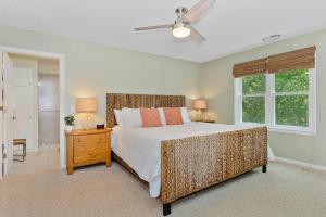 a bedroom with a large bed and a window at The Emerald Owl House - Peaceful Emerald Isle Beach House w/ Luxurious Heated Pool! in Emerald Isle +40 photos