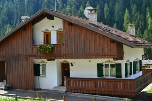 una casa con una fachada marrón y blanca en Cesa Elena, en Canazei