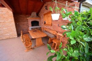 a patio with a wooden table and a fireplace at Apartmani Marko & Joso in Biograd na Moru