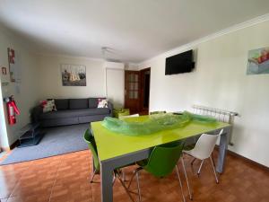 uma sala de estar com uma mesa amarela e cadeiras em Cantinho Verde T2 no Gerês