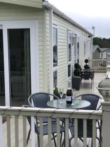 a patio with a table and two glasses of wine at Starlight Retreat in Swarland