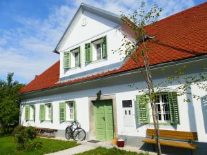 ein weißes Haus mit grünen Türen und einem roten Dach in der Unterkunft House 1797 - Charm of Slovenian Vintage in Dob