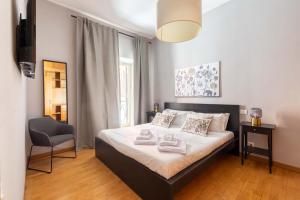 sypialnia z łóżkiem i krzesłem w obiekcie ELICAL Luxury Apartments w Rzymie