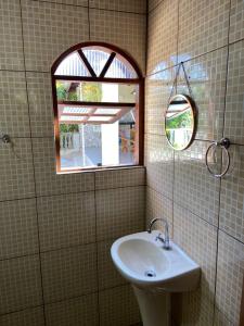 a bathroom with a sink and a mirror at Chalé Bela Vista in Areias