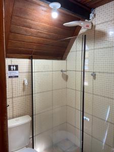 a bathroom with a toilet and a glass shower at Chalé Bela Vista in Areias