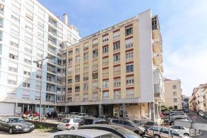 un grand bâtiment avec des voitures garées dans un parking dans l'établissement Apartment 66 With Parking Place, à Lisbonne