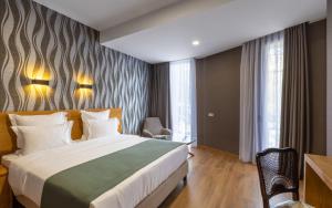 Habitación de hotel con cama y silla en Mukhrantubani Boutique Hotel en Tiflis