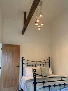 1 dormitorio con cama y lámpara de araña en Barford barn holiday cottage, en Darlington