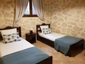 a bedroom with two beds and a window at cottage du soleil in Makry Gialos