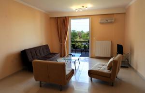 ein Wohnzimmer mit Sofa, Sesseln und Fernseher in der Unterkunft Dionysos Luxury Apartments in Nydri