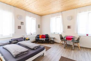 a bedroom with a bed and a table and windows at TAGBLATT Apartment 6 in Tuttlingen