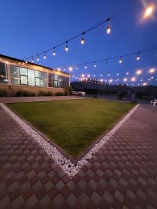 a building with lights and a lawn in front of it at Alreef farm in Ras al Khaimah