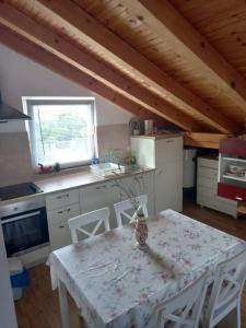 a kitchen with a table and chairs in a room at Apartman Kolona in Tkon