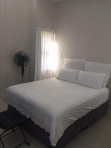 ein Schlafzimmer mit einem weißen Bett und einem Fenster in der Unterkunft Urban L010 in Durban