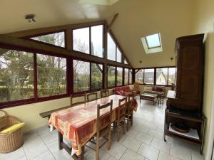 a dining room with a table and some windows at Maison La Roche-Posay, 5 pièces, 7 personnes - FR-1-541-17 in La Roche-Posay