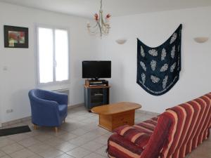 a living room with a couch and a tv at Maison avec Jardin proche Thermes comprenant Lave-linge et Lave-vaisselle - FR-1-541-47 in La Roche-Posay