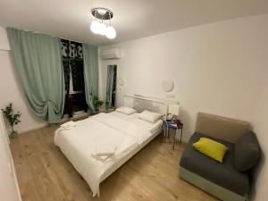 une chambre avec un lit et une chaise dedans dans l'établissement Green apartments 109-7 with roof top view, à Bucarest