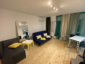 - un salon avec un canapé bleu et des oreillers jaunes dans l'établissement Green apartments 109-7 with roof top view, à Bucarest