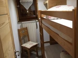 Cette petite chambre comprend des lits superposés et une chaise. dans l'établissement Appartement Le Grand-Bornand, 2 pièces, 4 personnes - FR-1-467-32, au Grand-Bornand