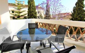 Una mesa de cristal y sillas en un balcón. en Pueblo del parque 12 - Terraza - Piscina y Playa- Urbanización tranquila- Perfecto para descansar, en Benalmádena