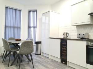 DYSA Banks Apartments في بلاكبول: مطبخ مع طاولة وكراسي في غرفة