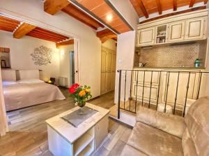 ein Schlafzimmer mit einem Bett, einem Sofa und einem Tisch in der Unterkunft Piazzetta Del Buonumore in Montepulciano
