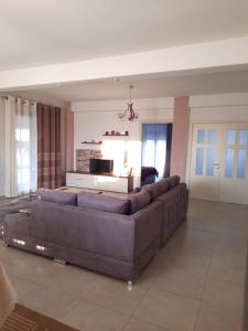 a large living room with a couch and a tv at Sun& Relax Home in Korçë