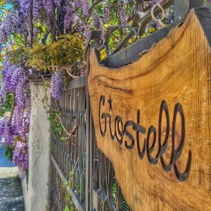 a wooden sign on a fence with purple flowers at B&B Giostell in Marina di Camerota