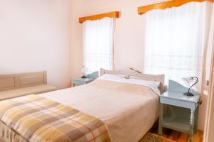 a bedroom with a bed and two tables and windows at Zelinia in Vitsa