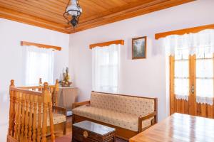 a living room with a table and chairs and windows at Zelinia in Vitsa