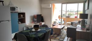 salon ze stołem i kubkiem w obiekcie Appartement avec grande terrasse à 15 mn de la mer w mieście Saint-Estève