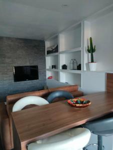 ein Wohnzimmer mit einem Tisch und Stühlen sowie einem TV in der Unterkunft Le Petit Cocon - Parking privé - Lyon Sud in Vénissieux